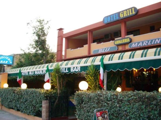 una tienda frente a un restaurante con toldos verdes y blancos en Hotel Blu Marlin, en Villasimius