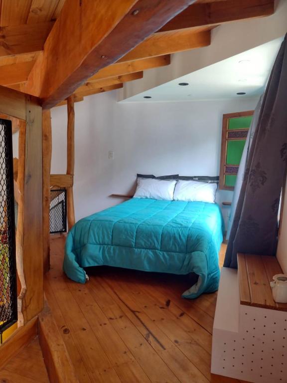 a bedroom with a bed in a room with wooden floors at casavillaza in Necochea