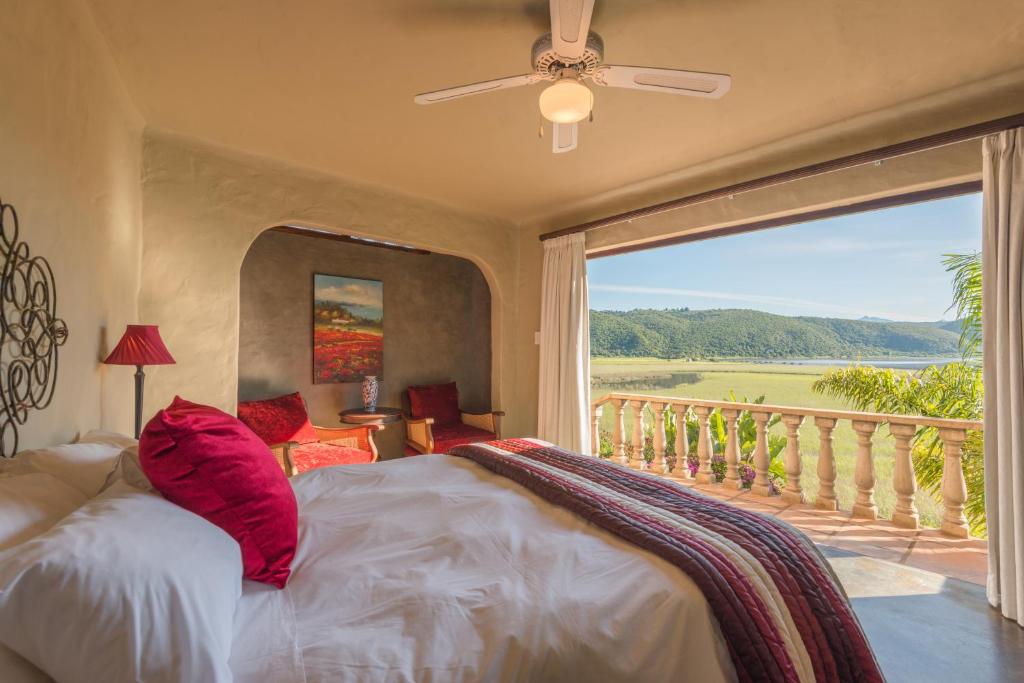 a bedroom with a large bed and a balcony at Tequila Moon in Wilderness