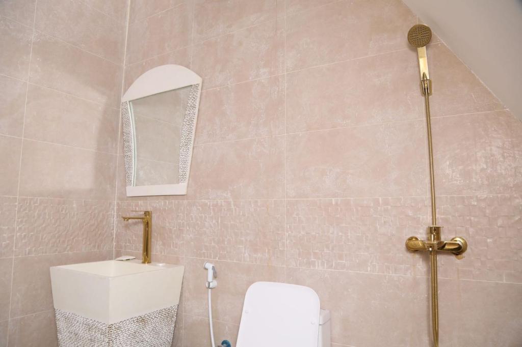 ein Badezimmer mit Toilette und Spiegel in der Unterkunft Malina Resort منتجع مالينا in Ras al Khaimah