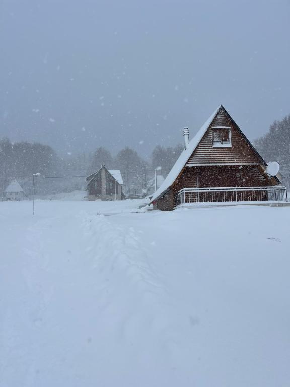 a barn covered in snow in a field at Snowflake in Žabljak