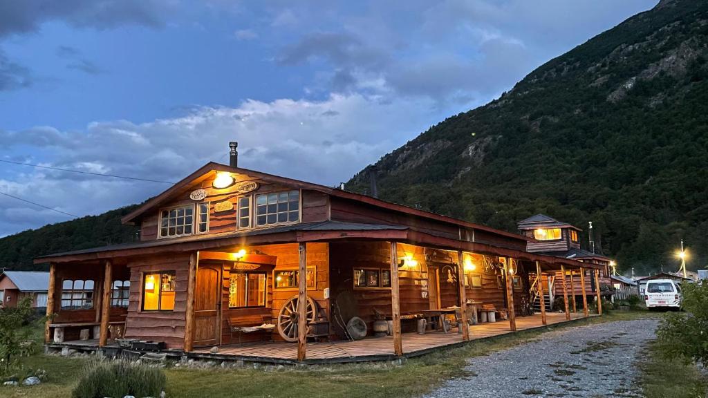 a wooden cabin with a mountain in the background at El Mosco in Villa O'Higgins