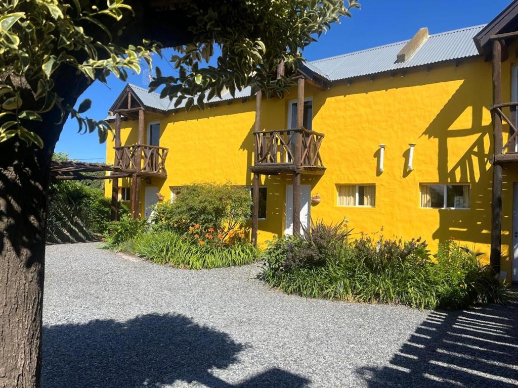 a yellow building with a pathway in front of it at Departamentos Serranos en Tandil in Tandil