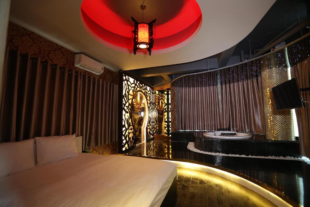 Habitación de hotel con cama y lámpara de araña roja. en Bonita Grand Hotel en Ho Chi Minh