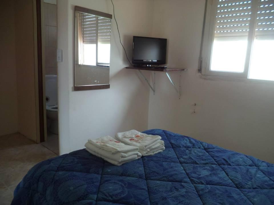 una camera con letto blu e TV a parete di Mar del Faro a Mar del Plata