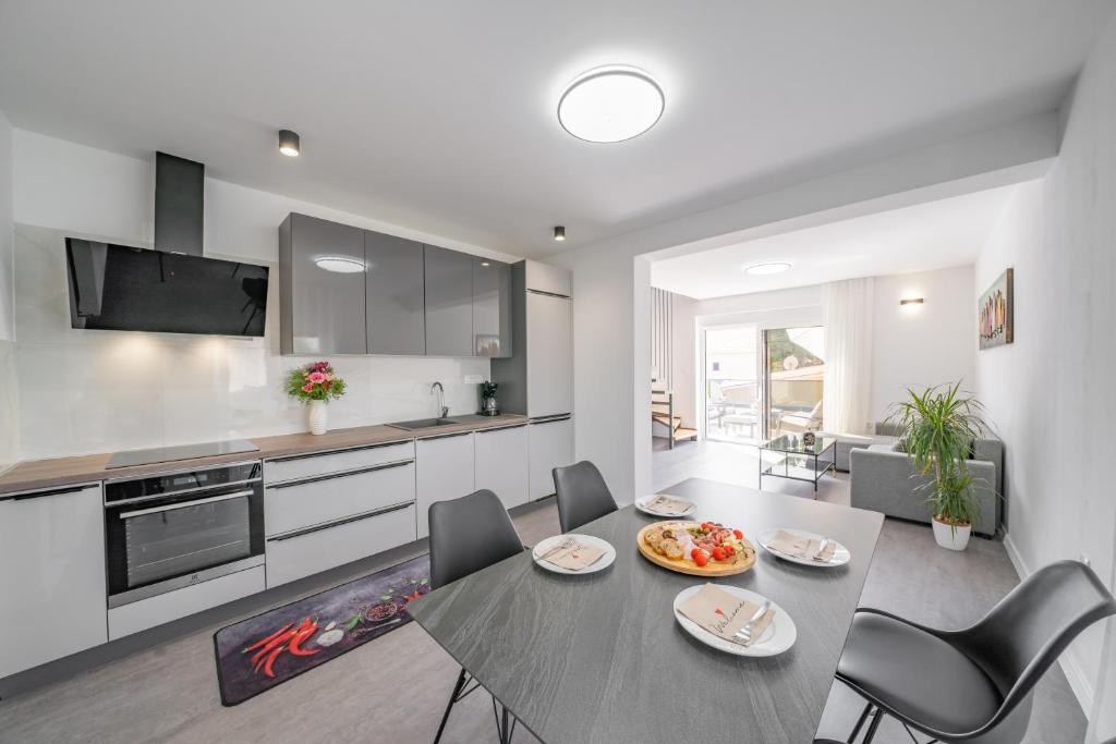 a kitchen and dining room with a table and chairs at Apartment Coral in Brodarica