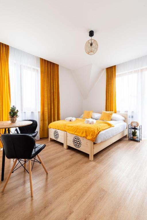 a bedroom with a bed and a desk and a chair at Apartamenty Podtatrzański in Leśnica