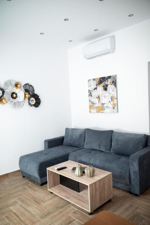 a living room with a blue couch and a coffee table at Kyra's Luxury Suites 2 in Chios