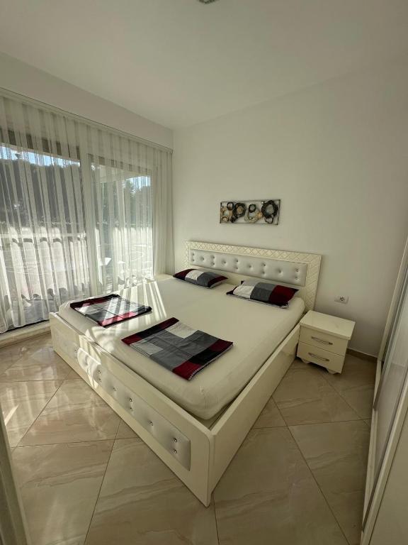 a bedroom with a large white bed in a room at Gjiri i Lalzit Lura 3 Apartment Toni in Draç