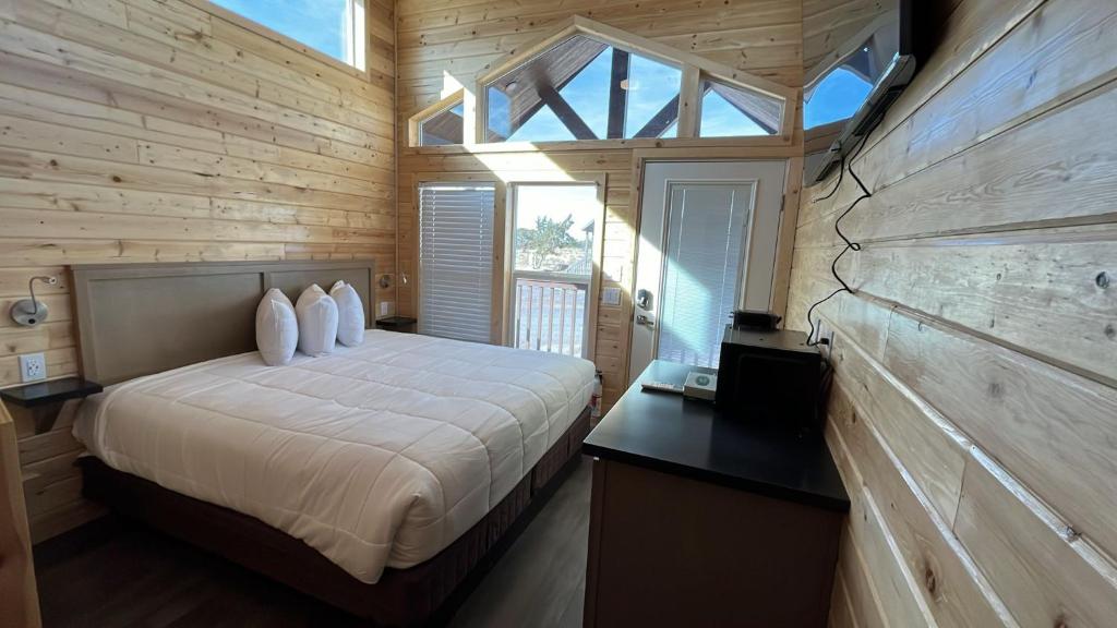 a bedroom with a bed in a wooden cabin at 064A Brand New Peaceful Chalet with Loft & King Bed near Grand Canyon South Rim in Valle