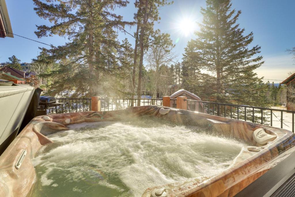 a hot tub in a backyard with water in it at Cozy Lead Cabin with Deck Less Than 1 Mi to Ski Slopes! in Lead