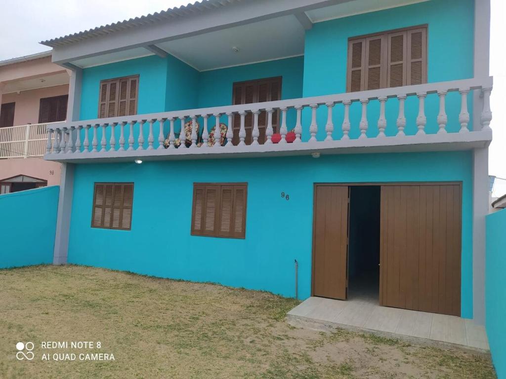 a blue house with a balcony at Sobrado a Beira Mar in Rio Grande