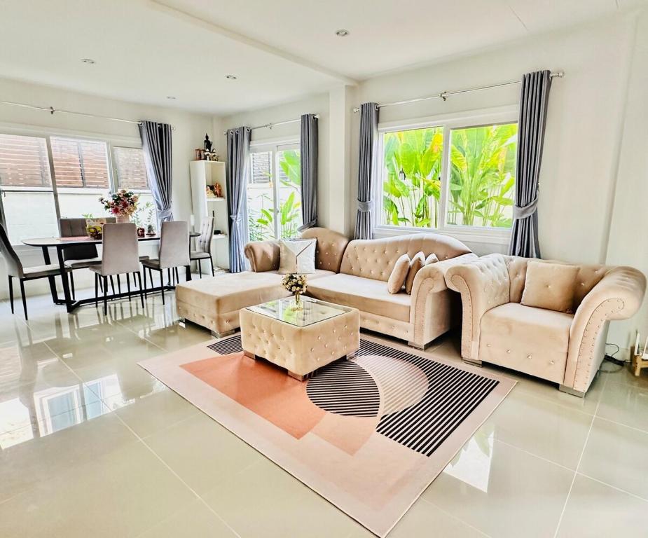 a living room with a couch and a table at Sirihouse at Supalai Bella Thalang Phuket in Phuket