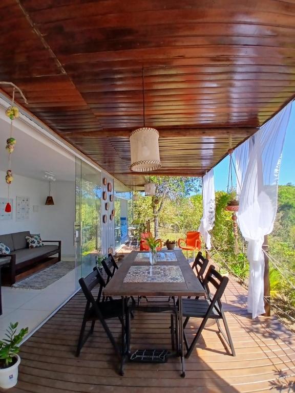 a dining room with a table and chairs on a deck at Casa Contêiner imersão com Natureza Floresta Sapiranga-5km praia do forte in Mata de Sao Joao