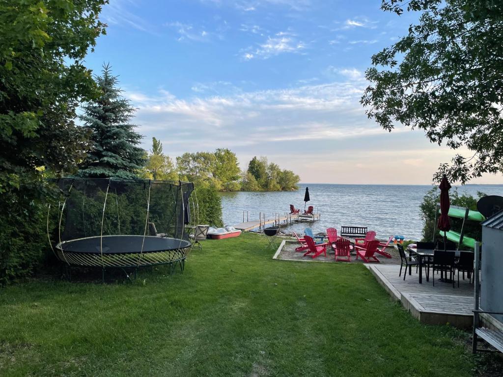 a backyard with a view of the water at Swing Bridge Cottage on Lake Simcoe - Waterfront in Brechin