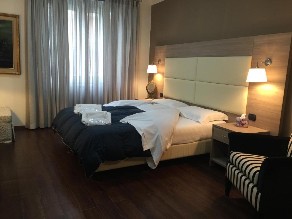 ローマにあるB&B Le Vibrazioniの大きなベッドと窓が備わるホテルルームです。