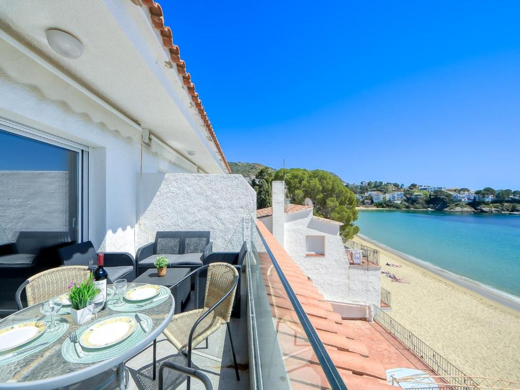 a balcony with a table and chairs and a view of the water at Beachfront Apartment in Platja Almadrava in Montjoys