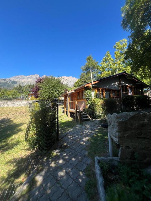 a cabin in a field with a fence at Cabañas Terraza Sur in El Bolsón