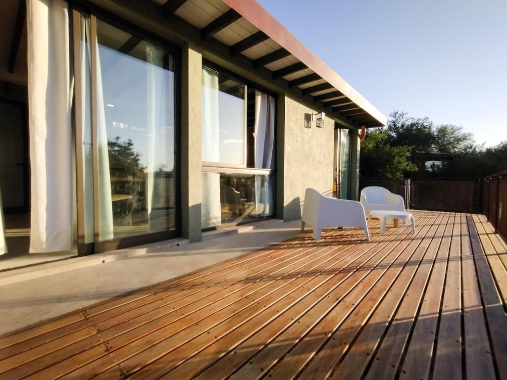 two white chairs sitting on a wooden deck at Refugio Verde en Nono, Córdoba in Nono