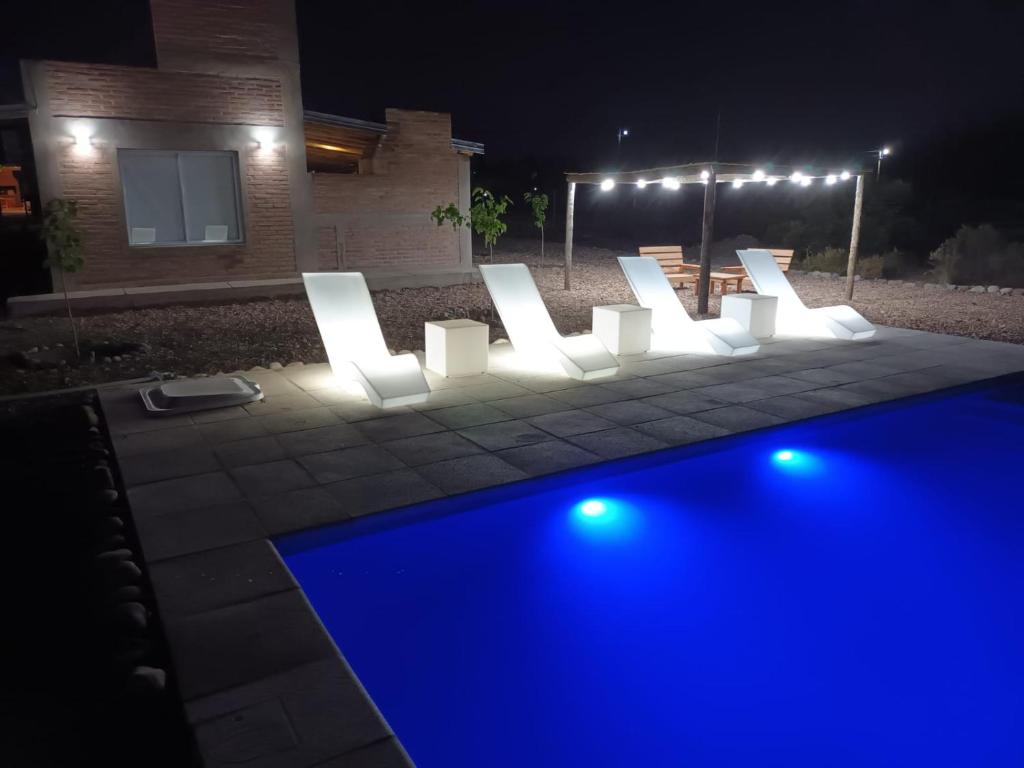 a pool with blue lights in a yard at night at Cabañas Jugueze San Rafael in San Rafael