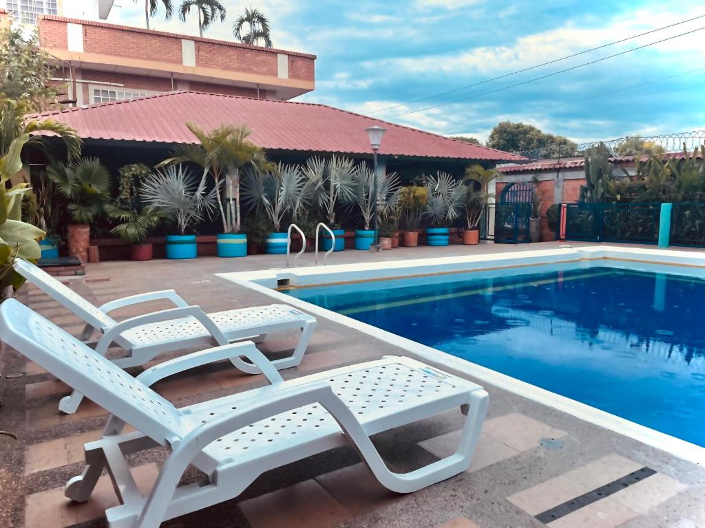 two lounge chairs sitting next to a swimming pool at Leño Verde in Espinal