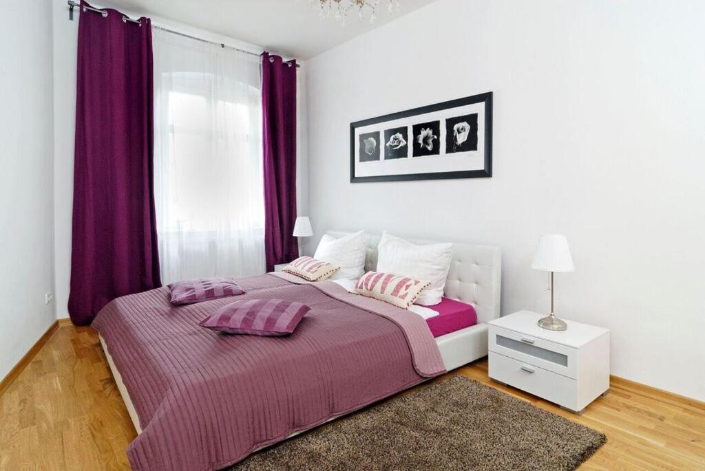 a bedroom with a bed with pink pillows on it at Grand Central Mitte Apartment in Berlin