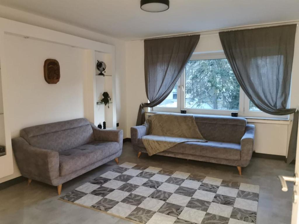ケルンにあるFamily-friendly apartment in Cologneのリビングルーム(椅子2脚、ソファ1台、窓付)