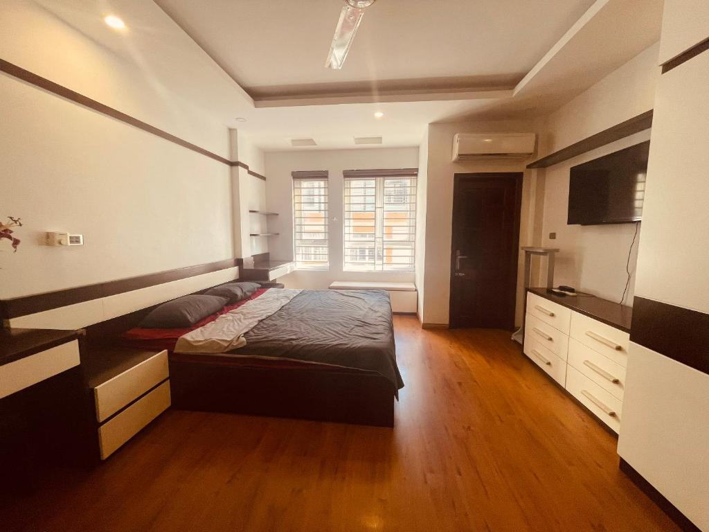 a large bedroom with a bed and a kitchen at Laca Home in Hanoi