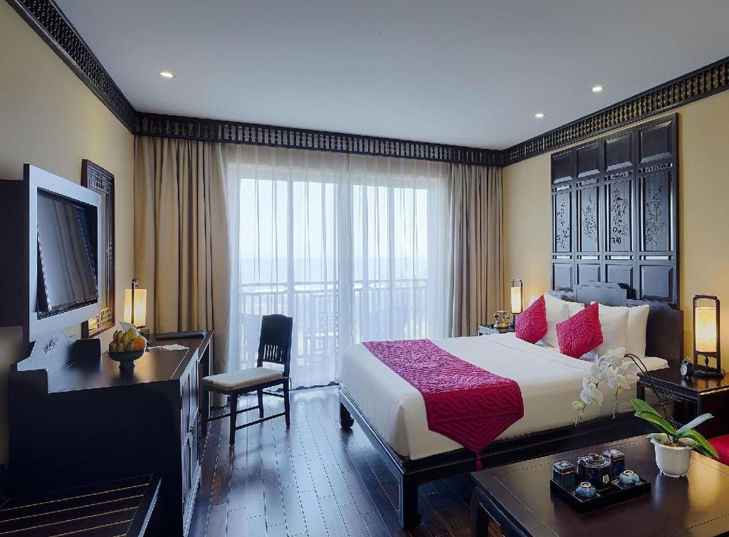 Postel nebo postele na pokoji v ubytování Wyndham Garden Hoi An Cua Dai Beach