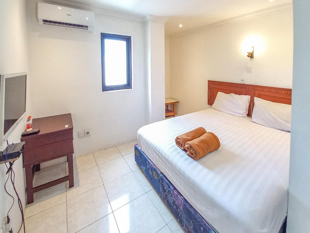 a hotel room with a bed with a towel on it at D Hans Hotel Syariah RedPartner near Wisata Religi Sunan Ampel Surabaya in Surabaya
