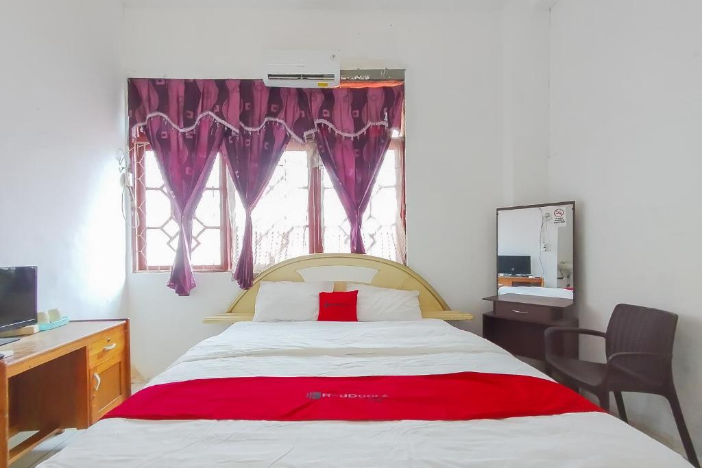 Ένα ή περισσότερα κρεβάτια σε δωμάτιο στο RedDoorz near Gapura Kota Banjarmasin