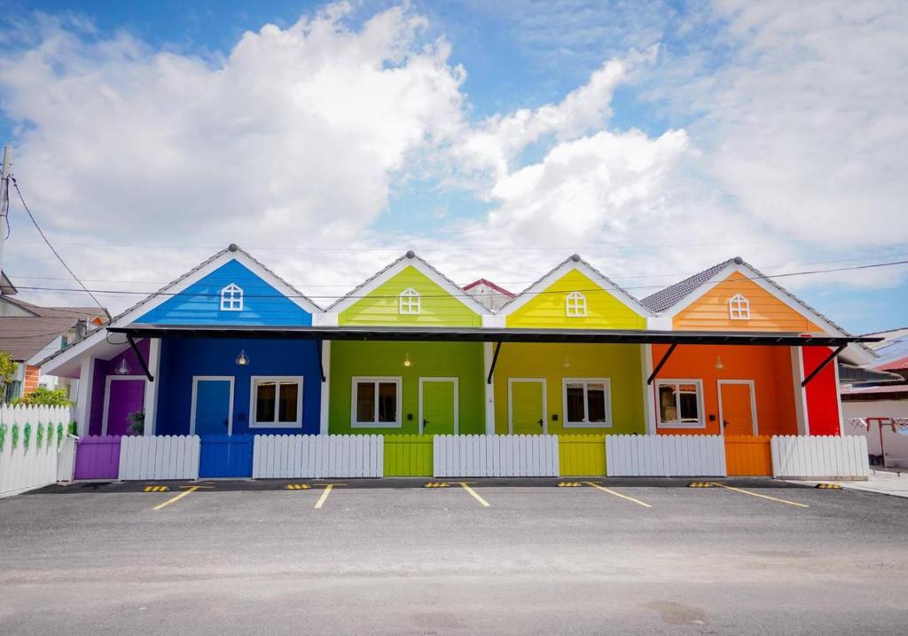 タナ・メラにあるAuranad TinyHouse bandar Tanah Merah Wifi Netflixの駐車場内の色彩豊かな家並み