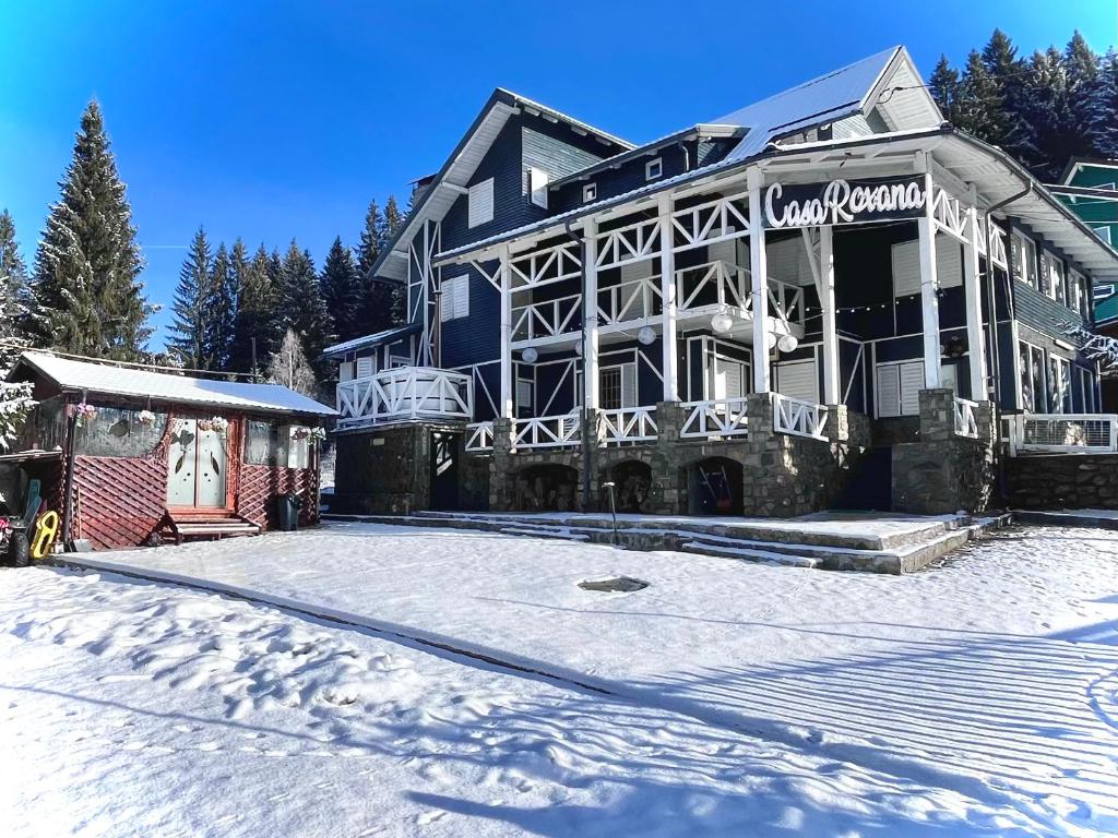 a large building with snow in front of it at Casa Roxana in Predeal