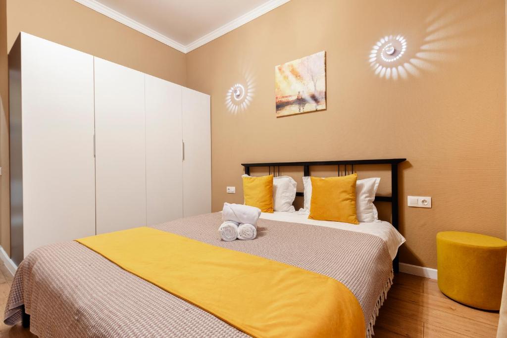 a bedroom with a bed with yellow sheets and yellow pillows at Абрикосовое парфе in Astana