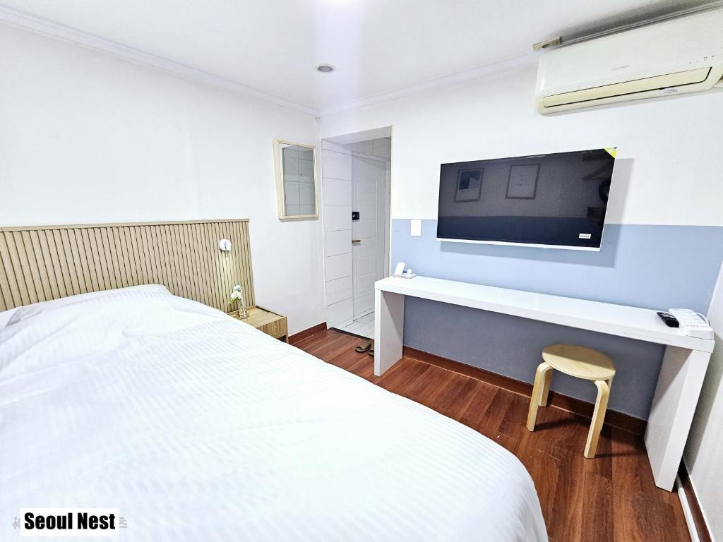 a bedroom with a bed and a desk with a tv at Seoul Nest in Seoul