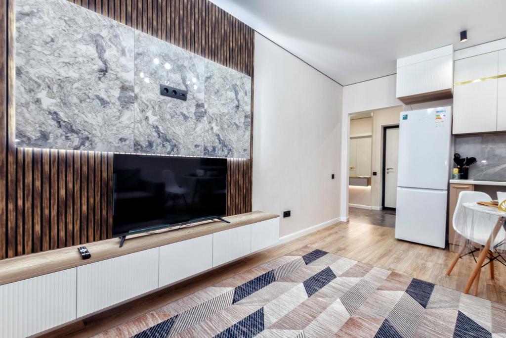 Una sala de estar con un televisor de pantalla plana grande. en Oasis апартаменты возле Хан-Шатыра, en Astana