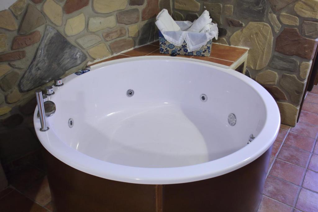 a bath tub in a room with a stone wall at Casa Rural La Tejada in Alcalá de Moncayo
