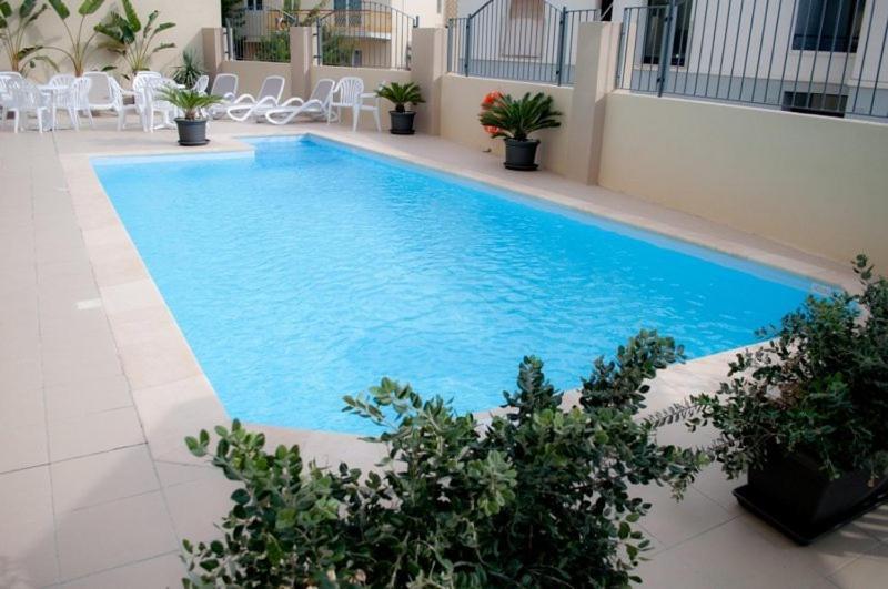 San Ġwann的住宿－卡帕拉酒店，一座建筑物中央的游泳池