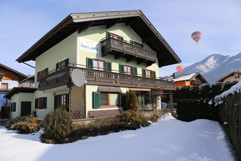 a building with a balcony and a hot air balloon in the sky at Haus Vera in Zell am See