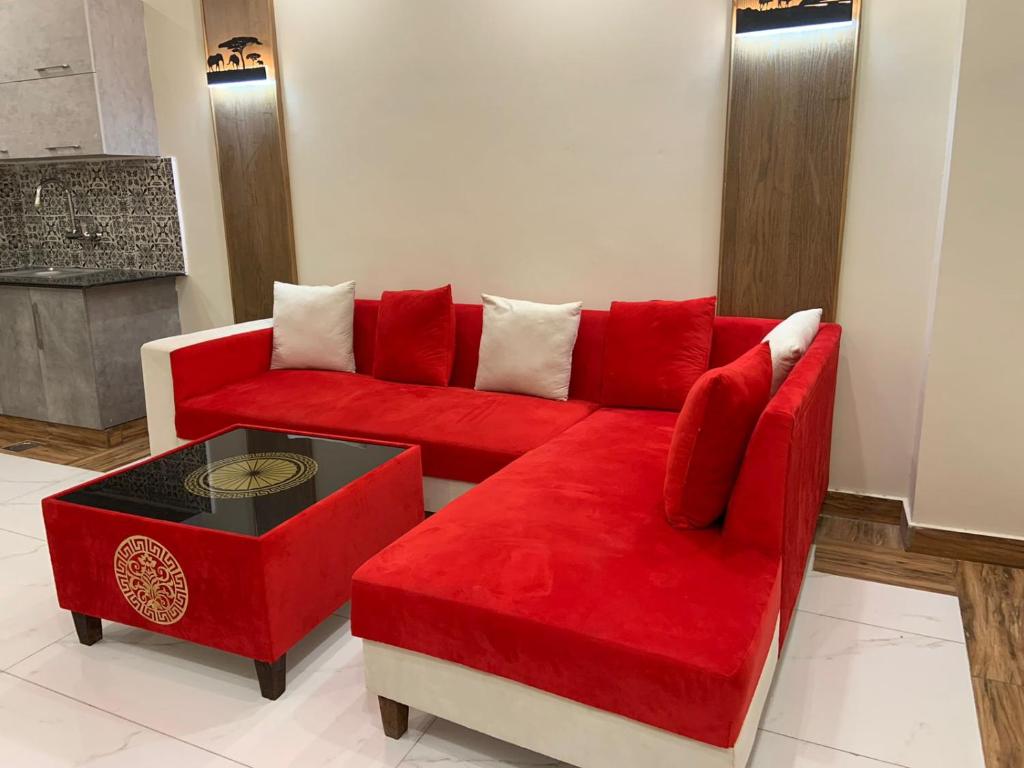 a living room with a red couch and a table at Royal Galaxy Hotel & Residence - Near Islamabad International Airport & Motorway in Islamabad