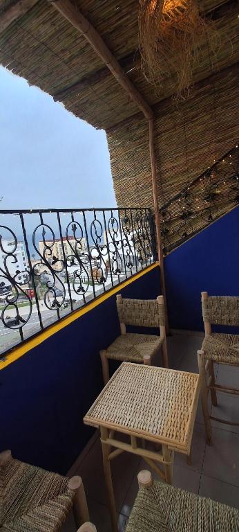 a balcony with a table and chairs and a railing at Cozy Flat With Sea View in Tangier