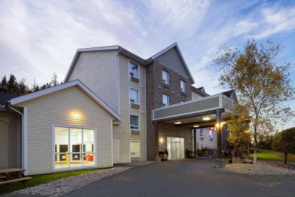 een huis met een gambrel dak bij Super 8 by Wyndham Sainte Agathe Des Monts in Sainte-Agathe-des-Monts