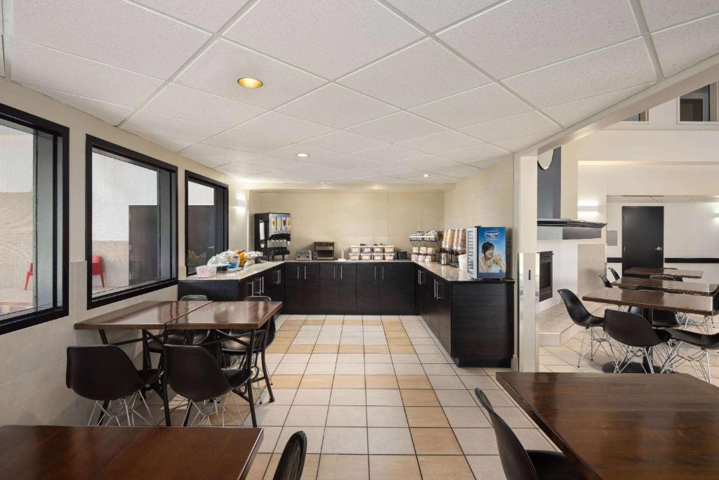 een keuken en eetkamer met tafels en stoelen bij Super 8 by Wyndham Sainte Agathe Des Monts in Sainte-Agathe-des-Monts