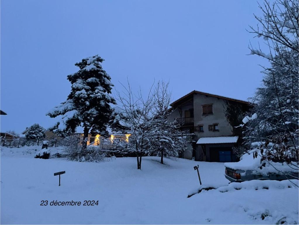 une cour enneigée avec une maison en arrière-plan dans l'établissement Rez de villa entre ville et montagne, à Brié-et-Angonnes