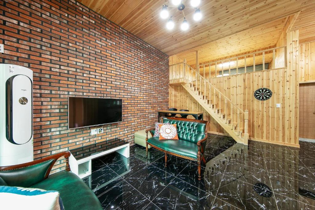 a living room with a tv and a couch and a chair at Gapyeong Twelve Pension in Gapyeong