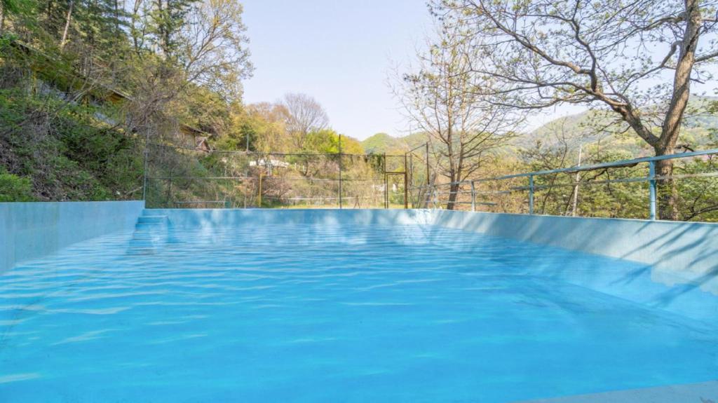 a large swimming pool with blue water at Yangpyeong santa pension in Yangpyeong