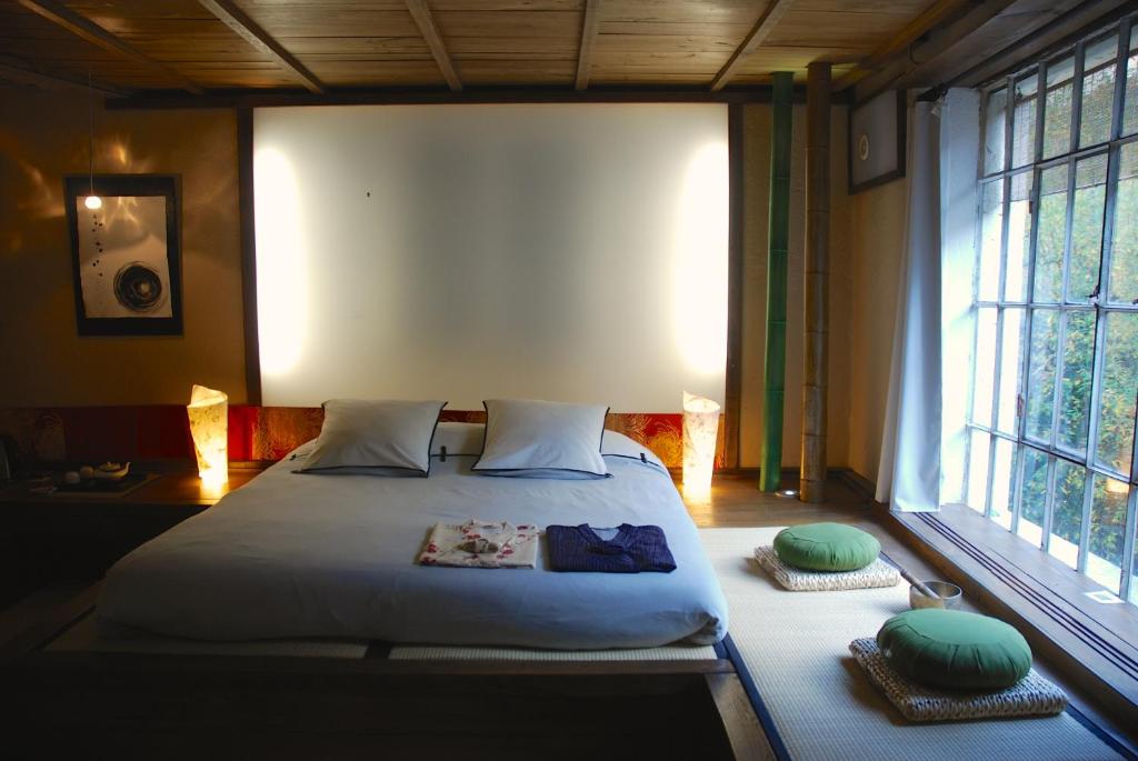 a bedroom with a large bed with two pillows on it at Minshuku Chambres d'hôtes japonaises in Thiers