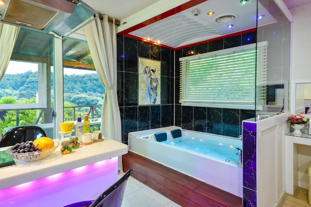 a bathroom with a tub and a table and chairs at Gapyeong Ashely Pension in Gapyeong