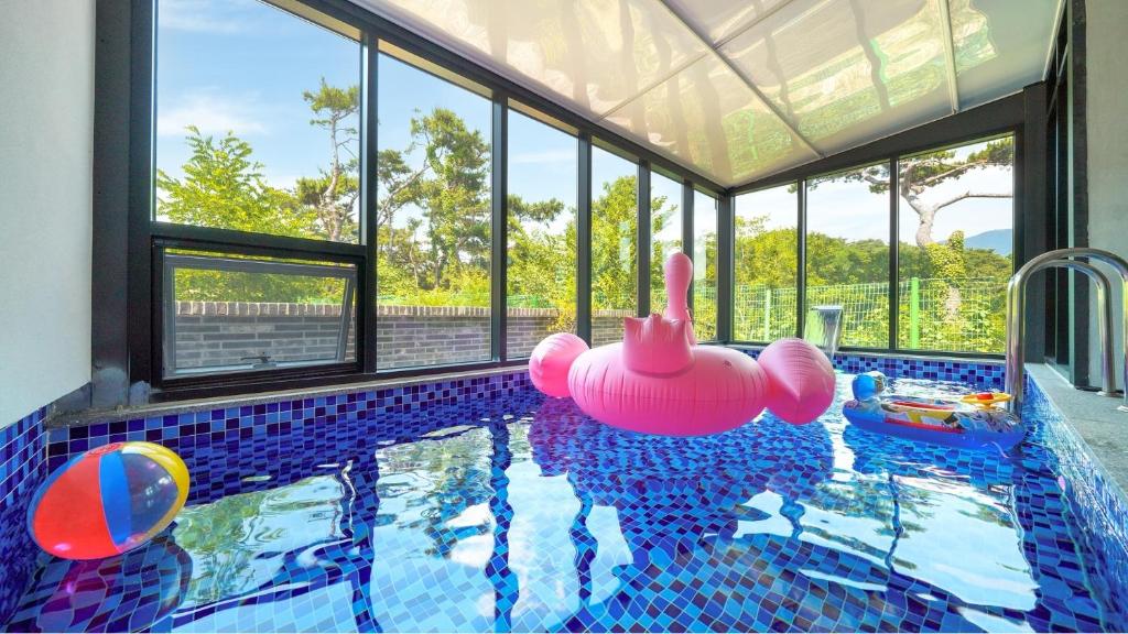 a swimming pool with a pink inflatable rubber duck in a house at Gyeongju Blibli Poolvilla in Gyeongju