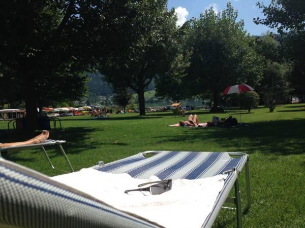 eine Gruppe von Menschen, die auf dem Gras in einem Park liegen in der Unterkunft Familienurlaub am See in Bodensdorf